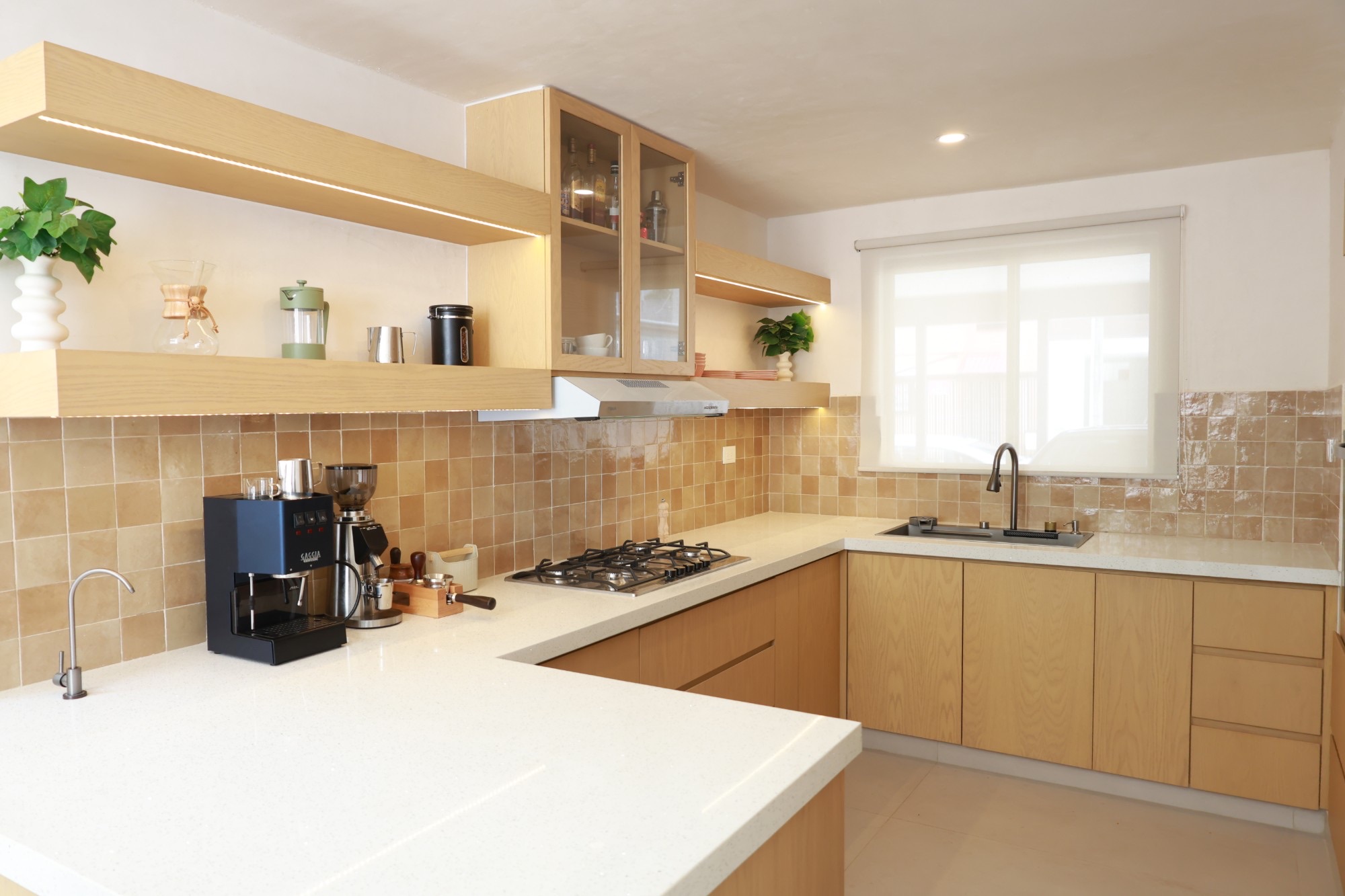 Cocina en U con gabinetes de roble y repisas iluminadas