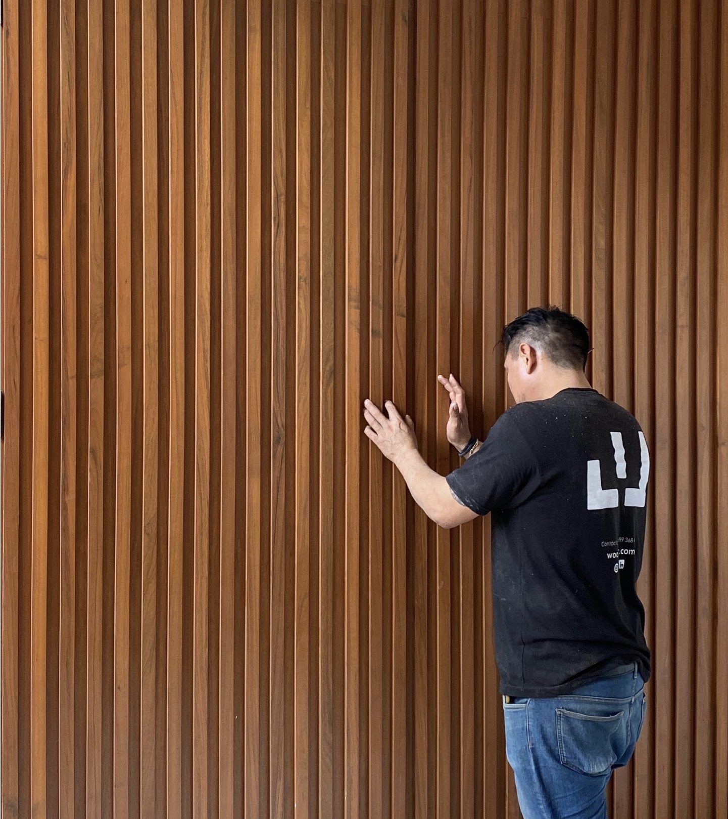 Maestro carpintero revisando un muro de listones de madera