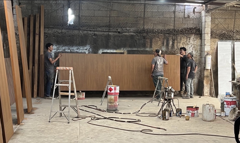 Equipo de producción armando un panel de madera